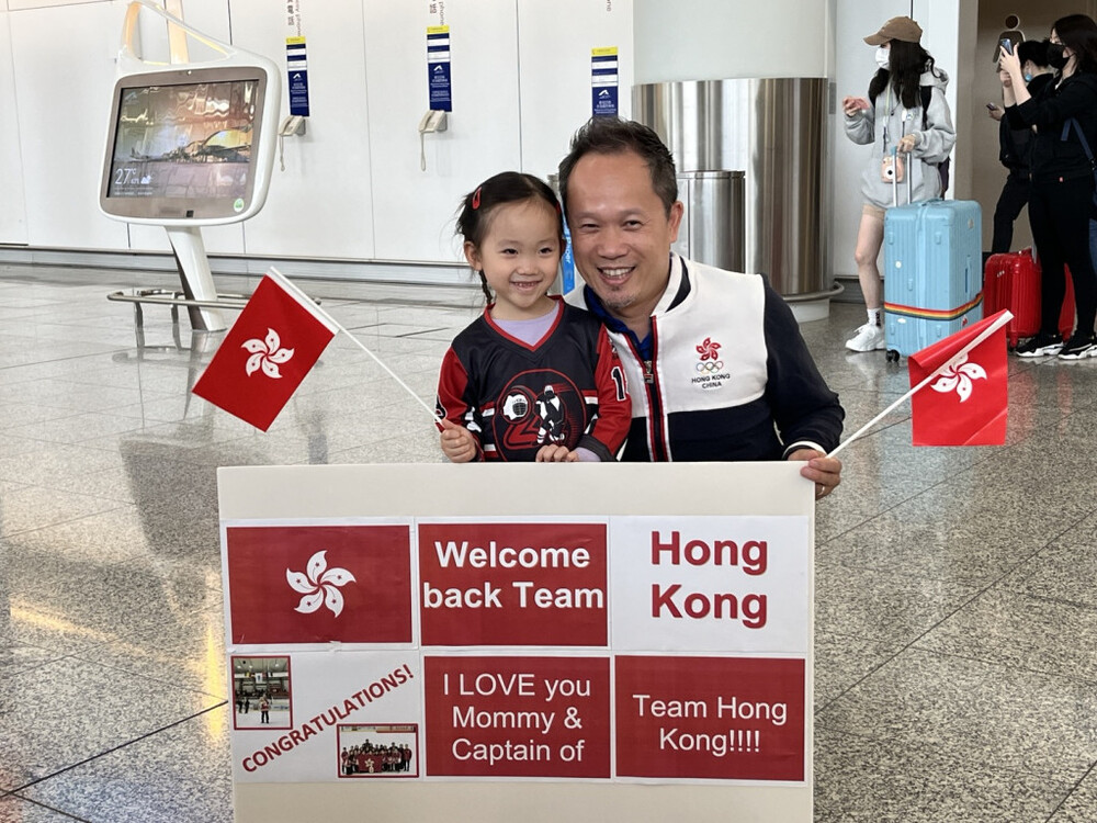 Kayla (left), the five-year-old daughter of women's team captain Adrienne Li, and Li's husband (right). 