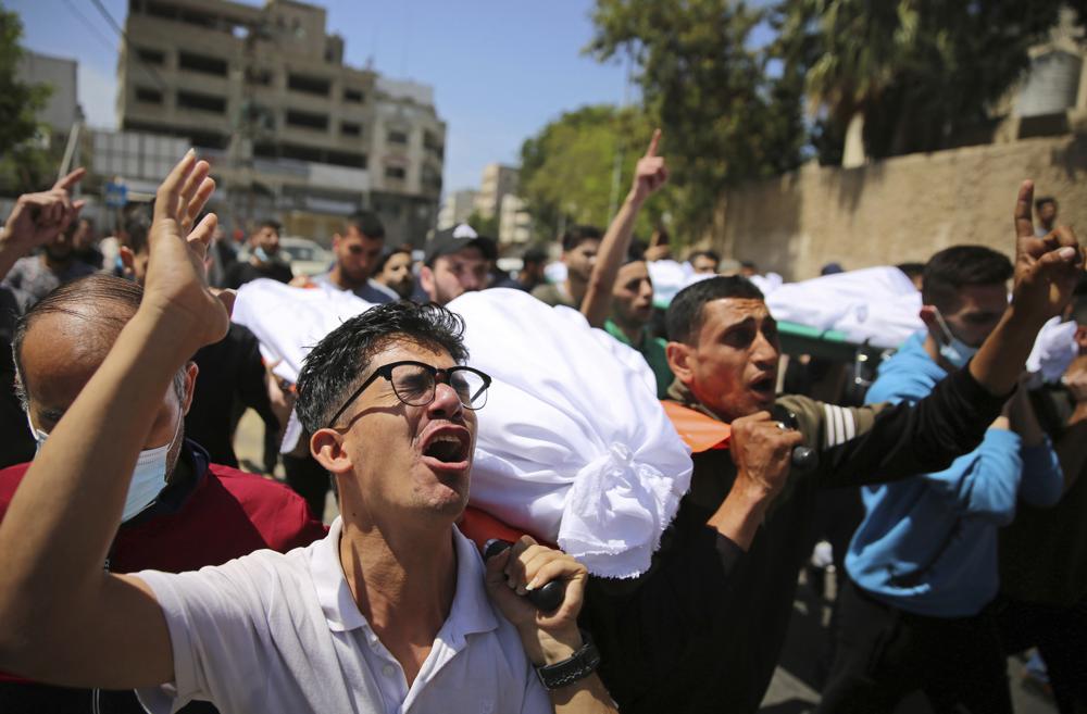 Mourners carry the the bodies of Palestinians who were killed in overnight Israeli airstrikes that hit their homes, during their funeral in Gaza City, Sunday, May 16, 2021.