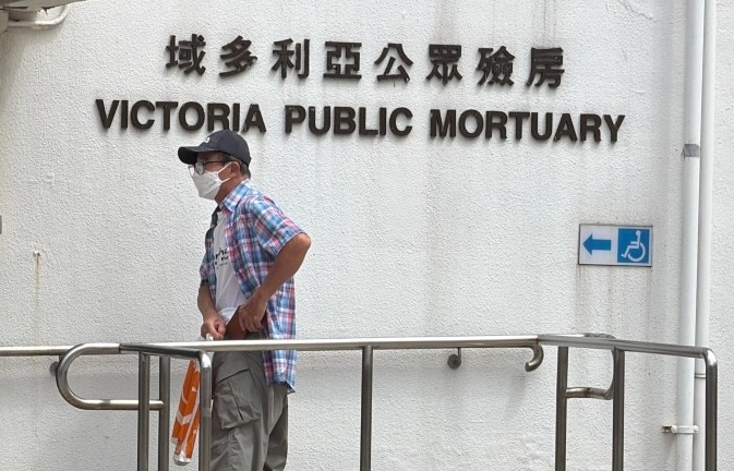 Mui Kai-ming arrives at the mortuary on Monday morning.