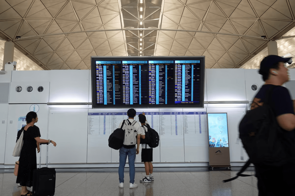 Passengers check flight information display screens at Hong Kong International Airport in Hong Kong, China June 16, 2025. REUTERS/Joyce Zhou