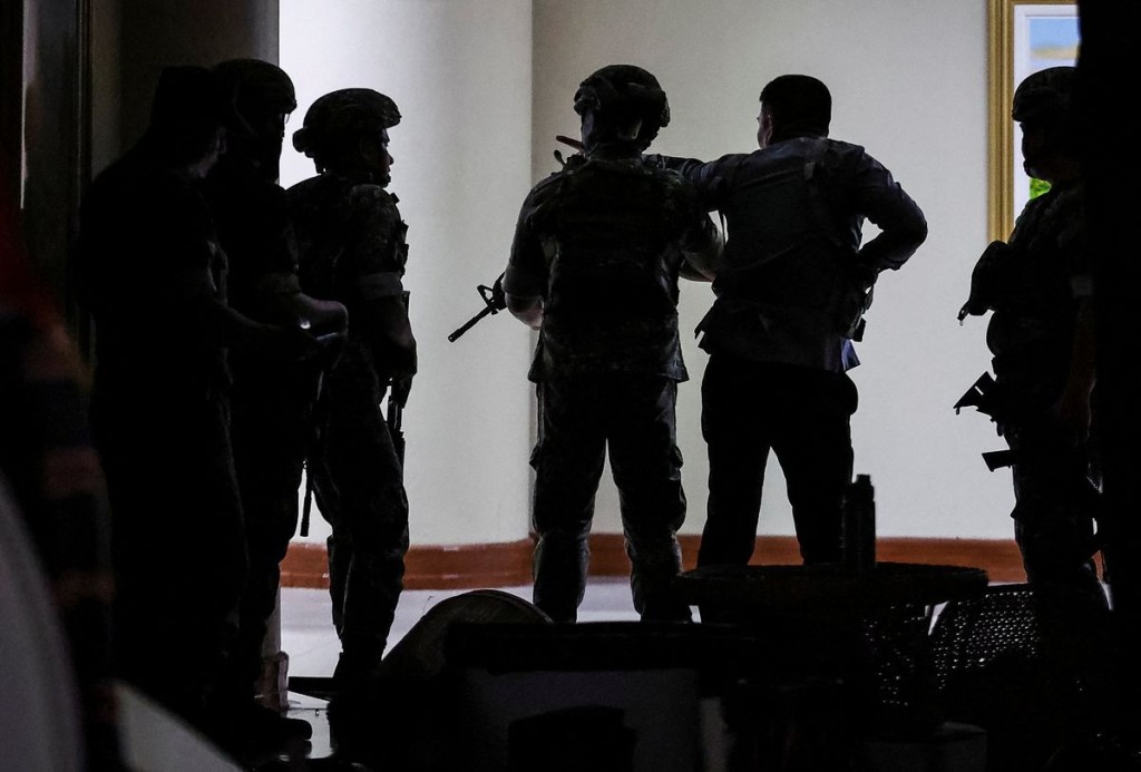 Military personnel in camouflage fatigues enter the Senate building. Reuters