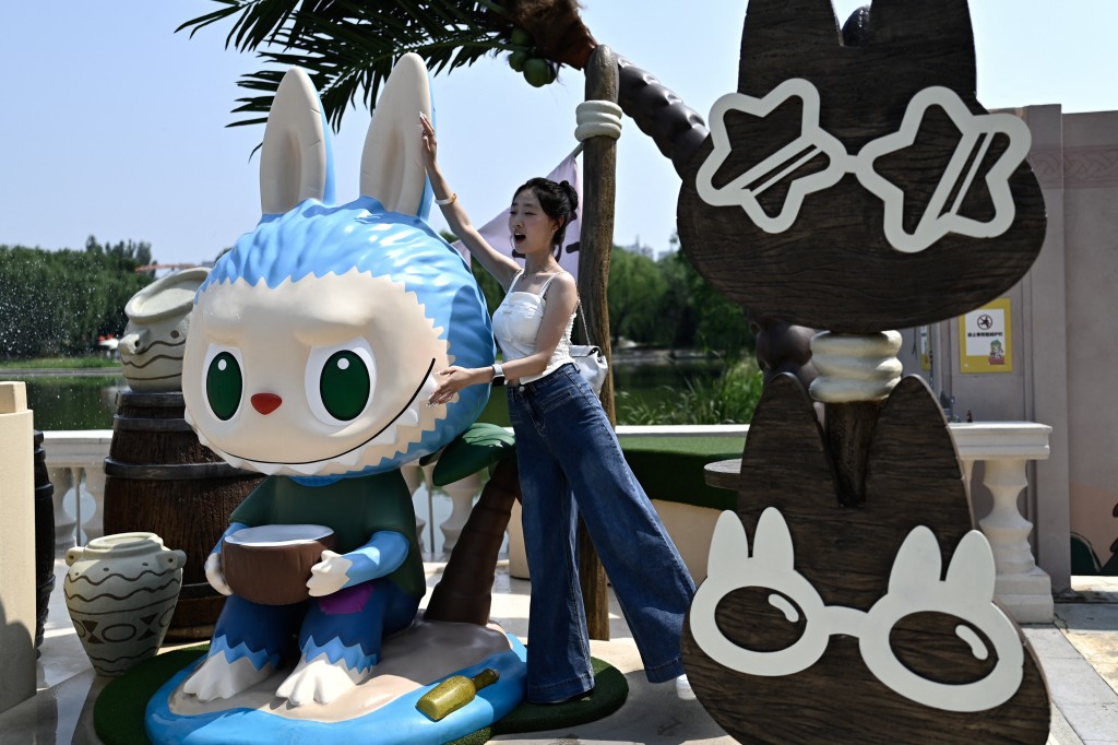 A woman posing for a picture next to the character Labubu as she visits Pop Mart’s theme park Pop Land in Beijing. (AFP)