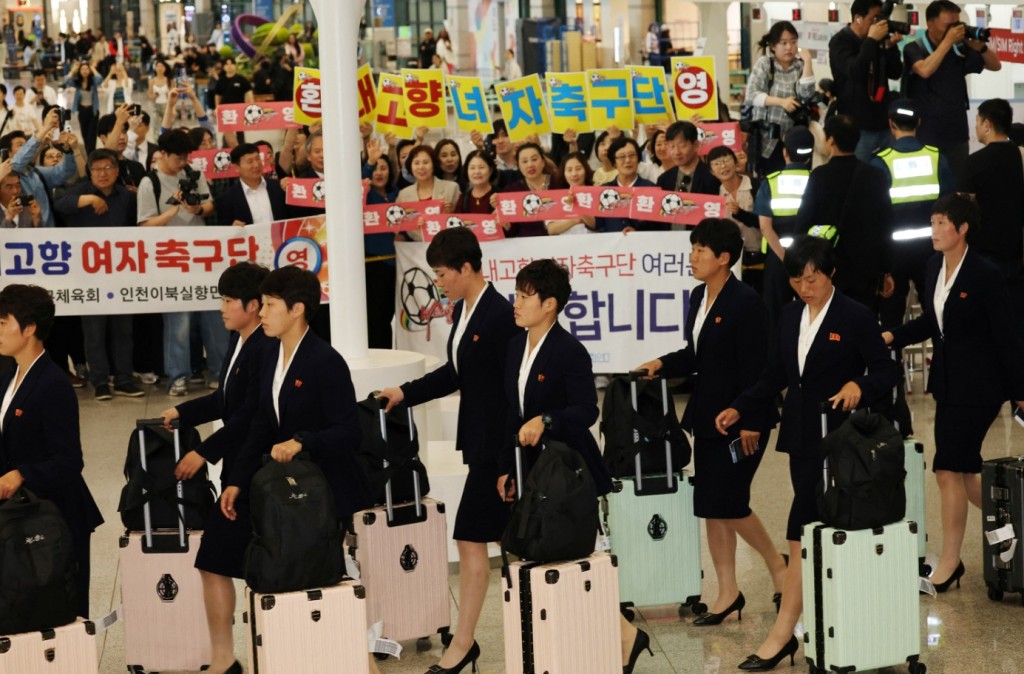 Members of the Naegohyang women’s football team are welcomed by civic groups at the airport. REUTERS