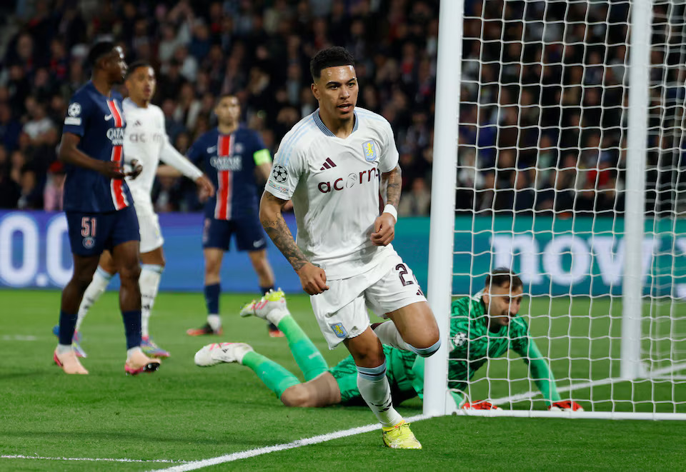 Soccer Football - Champions League - Quarter Final - First Leg - Paris St Germain v Aston Villa - Parc des Princes, Paris, France - April 9, 2025 Aston Villa's Morgan Rogers celebrates scoring their first goal as Paris St Germain's Gianluigi Donnarumma looks dejected REUTERS/Stephanie Lecocq