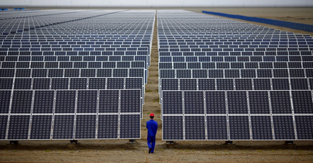 A worker inspects solar panels at a solar Dunhuang, 950km (590 miles) northwest of Lanzhou, Gansu Province in this September 16, 2013. REUTERS/Carlos Barria