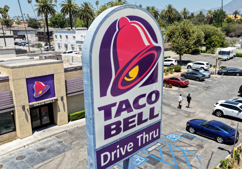 In an aerial view, customers depart a Taco Bell restaurant on July 14, 2026 in Pasadena, California. Federal and state health officials have reportedly begun investigating whether lettuce served at some Taco Bell restaurants has led to the widespread outbreak of cyclosporiasis, a gastrointestinal illness, which has sickened thousands around the country. Mario Tama/Getty Images/AFP