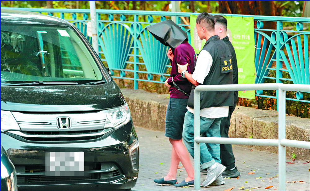 The suspect is escorted to the park for a reenactment. Below, earlier in the day, people pass by the area where the body was found. SING TAO The suspect is escorted to the park for a reenactment. Below, earlier in the day, people pass by the area where the body was found. SING TAO