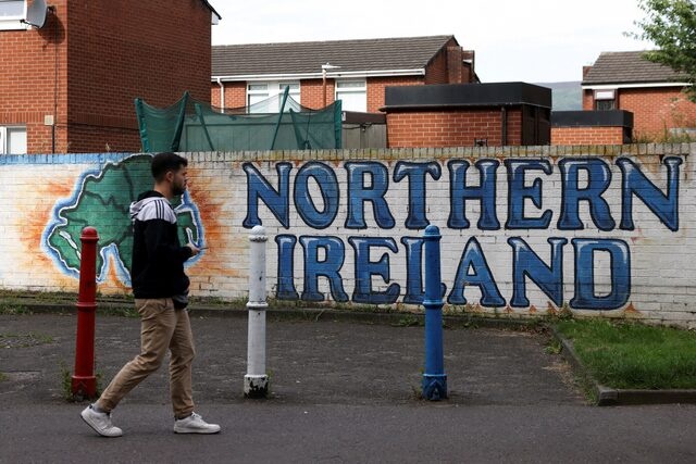 A man walks past a mural that says ‘Northern Ireland’, on Sandy Row in Belfast, Northern Ireland, August 11, 2024. REUTERS/Hollie Adams/File Photo 
