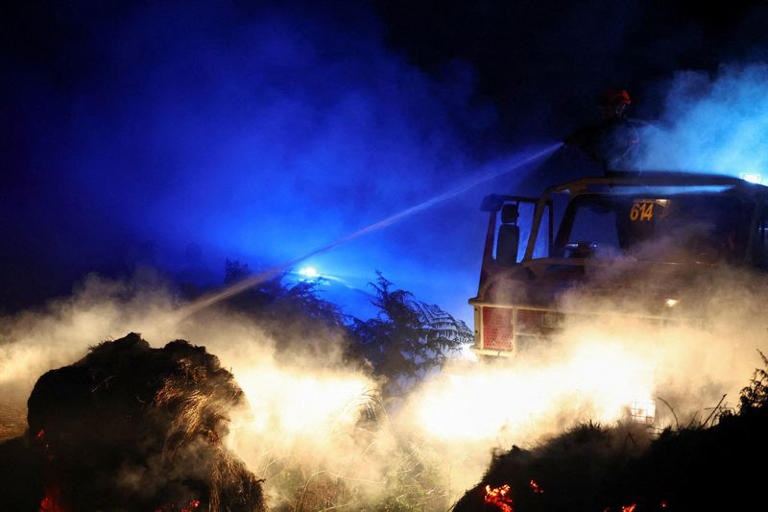 A firefighter works to extinguish a wildfire near Saint-Vallier, south-western France, August 12. REUTERS/Abdul Saboor © Thomson Reuters