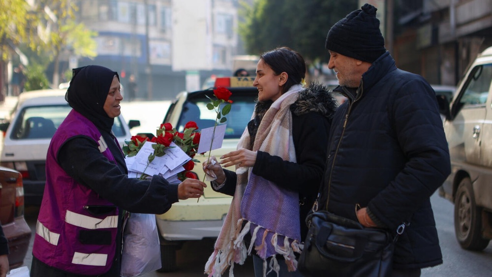 A woman offers a rose to a pedestrian in Aleppo, the first major city taken by rebels on their rapid push that ended with the fall of Bashar al-Assad's government © AAREF WATAD / AFP A woman offers a rose to a pedestrian in Aleppo, the first major city taken by rebels on their rapid push that ended with the fall of Bashar al-Assad's government © AAREF WATAD / AFP