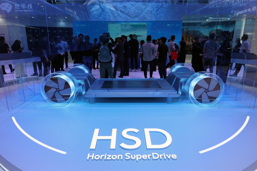 People stand near a display of Horizon SuperDrive smart driving system at the Horizon Robotics booth during a media day for the Auto Shanghai show in Shanghai, China April 23, 2025. REUTERS/Go Nakamura
