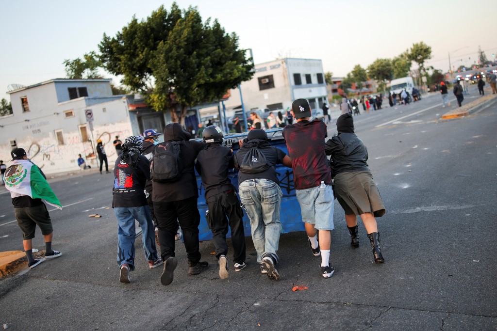 Protesters push a dumpster during a standoff between police and protesters following multiple detentions by Immigration and Customs Enforcement (ICE), in the Los Angeles County city of Paramount, California, U.S., June 7, 2025. (Reuters)