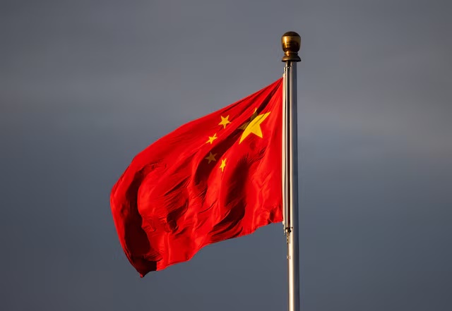 China’s national flag flutters in the wind lit by sunrise in Beijing, China, November 20, 2025. REUTERS/Maxim Shemetov
