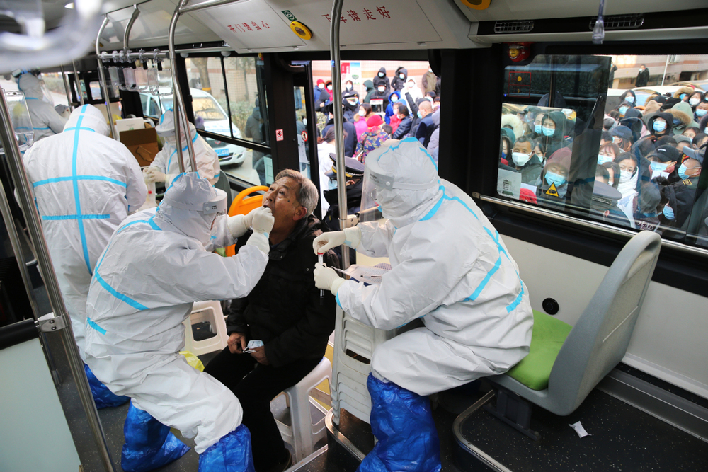 Medical workers carry out coronavirus testing in the Hebei capital Shijiazhuang, on Thursday, from one of 36 converted buses being used to get in and out of communities. Medical workers carry out coronavirus testing in the Hebei capital Shijiazhuang, on Thursday, from one of 36 converted buses being used to get in and out of communities.
