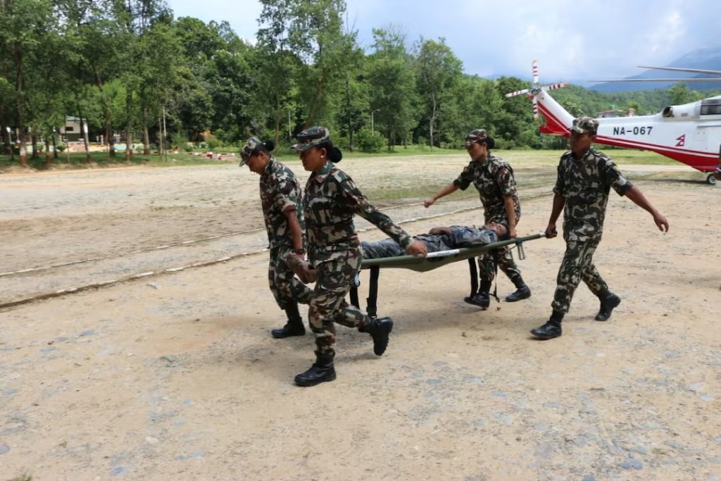 Nepali army soldiers move a survivor on a stretcher following flash floods and a mudslide near the Nepal-Tibet border in Nepal, in this handout image obtained on August 27, 2026. Nepali Army/Handout via REUTERS 