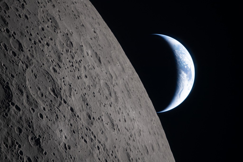 Photo by HANDOUT / NASA / AFP  This handout picture released on April 7, 2026, by NASA shows crescent Earth setting along the Moon's limb, as seen from the Orion spacecraft on April 6, 2026.