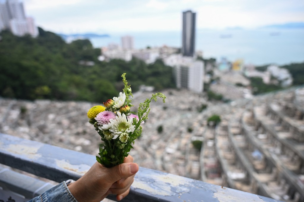 Philip Chiu holding flowers for his late sister Chiu Siu-king, who was killed in the Lamma IV ferry sinking in October 2012, at the Pok Fu Lam cemetery in Hong Kong. (AFP)