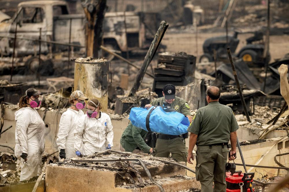 Sheriff's Deputy Johnson carries remains of a McKinney Fire victim from a destroyed home on Monday, Aug. 1, 2022, in Klamath National Forest, Calif. (AP) Sheriff's Deputy Johnson carries remains of a McKinney Fire victim from a destroyed home on Monday, Aug. 1, 2022, in Klamath National Forest, Calif. (AP)