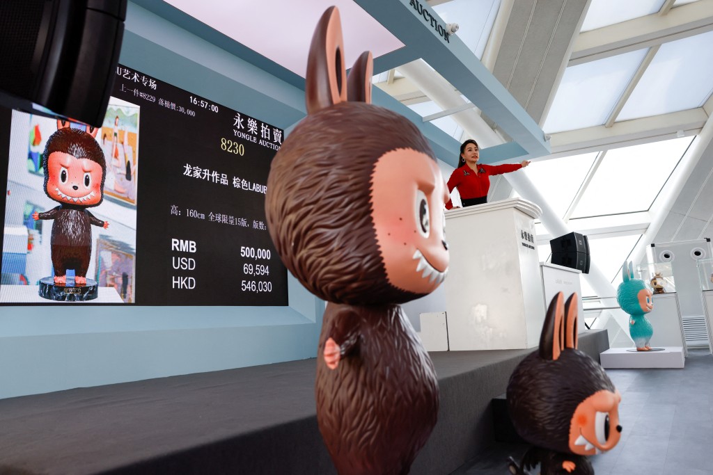 An auctioneer takes bids from buyers for a Labubu figurine, during an auction by Yongle International Auction in Beijing, China June 10, 2025. REUTERS
