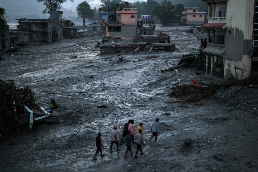 People walk next to damaged buildings, following the deadly flash floods and mudslides in Devighat, Nuwakot district, Nepal, September 3, 2026. REUTERS/Athit Perawongmetha