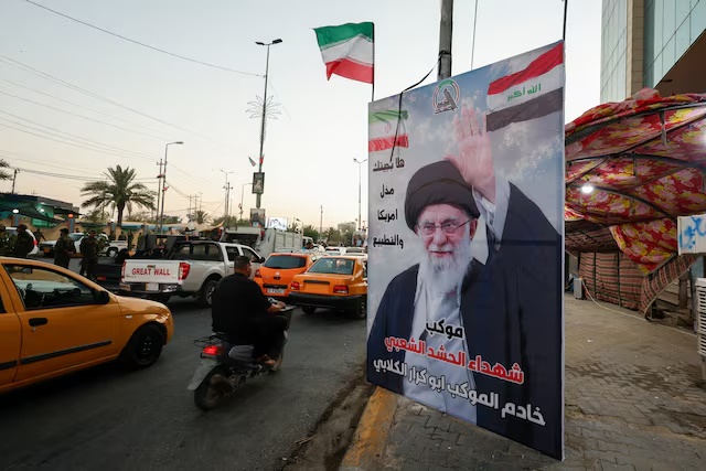 Commuters drive past a poster of Iran's late Supreme Leader Ayatollah Ali Khamenei ahead of funeral processions, in Karbala, Iraq, July 7, 2026. REUTERS/Khalid Al-Mousily