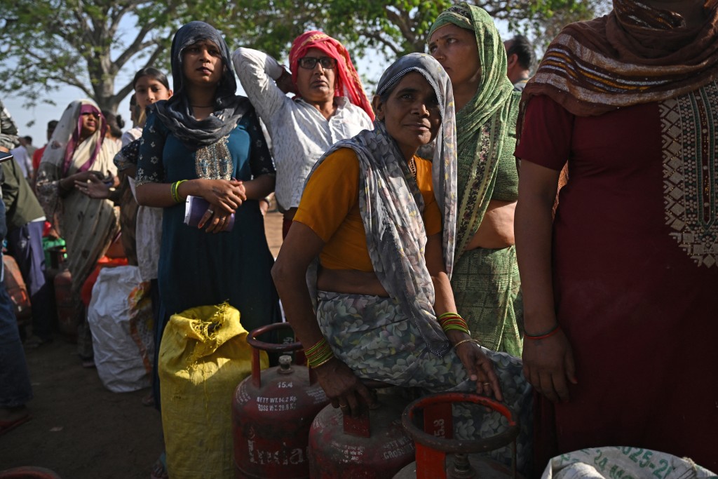 Photo by ARUN SANKAR / AFP  This photograph taken on April 24, 2026 shows people waiting with empty LPG (liquefied petroleum gas) cylinders for refilling, in a village on the outskirts of Uttar Pradesh's Jewar district.
