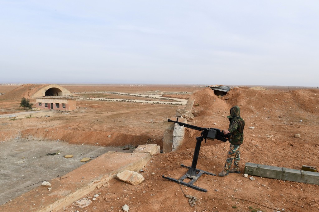 Photo by GEORGE OURFALIAN / AFP  A member of Syrian government forces, stands guard the Abu Duhur military air base area in Idlib province, on January 21, 2018.