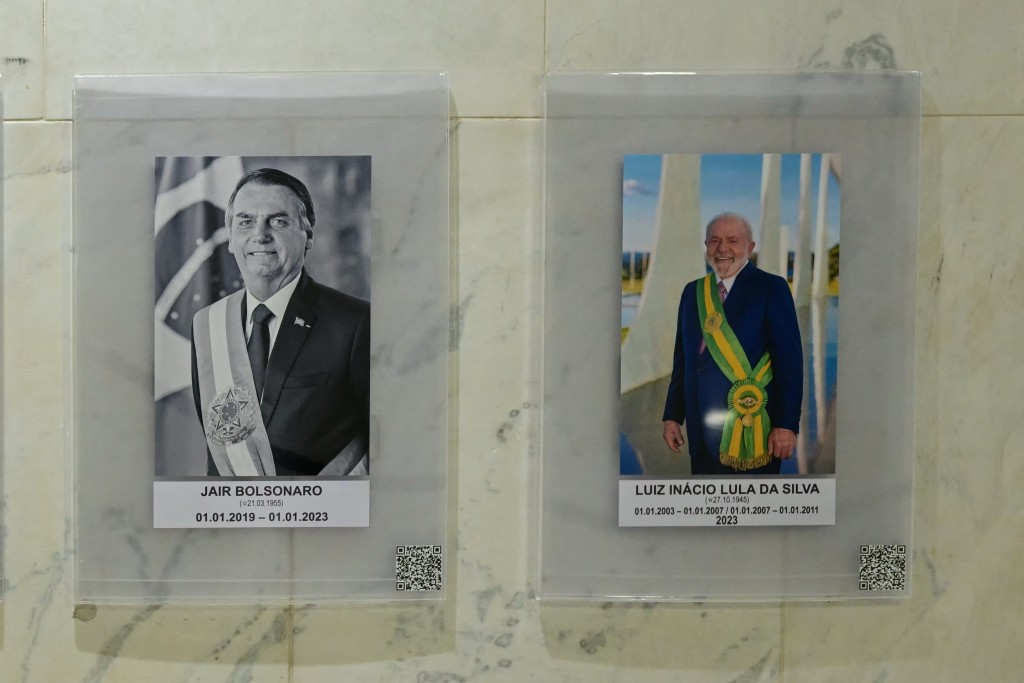 Portraits of former Brazilian President Jair Bolsonaro and current President Luis Ignacio Lula da Silva are pictured at Planalto Palace in Brasilia on September 10, 2025. Two judges in Brazilian ex-president Jair Bolsonaro's coup trial voted on September 9 to convict him, with three others yet to give their verdicts in a case that has angered the right-winger's US ally Donald Trump. (Photo by Pablo PORCIUNCULA / AFP)