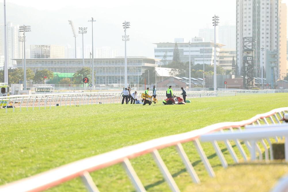Paramedics rushing onto the track to treat the three dislodged jockeys in race 9.