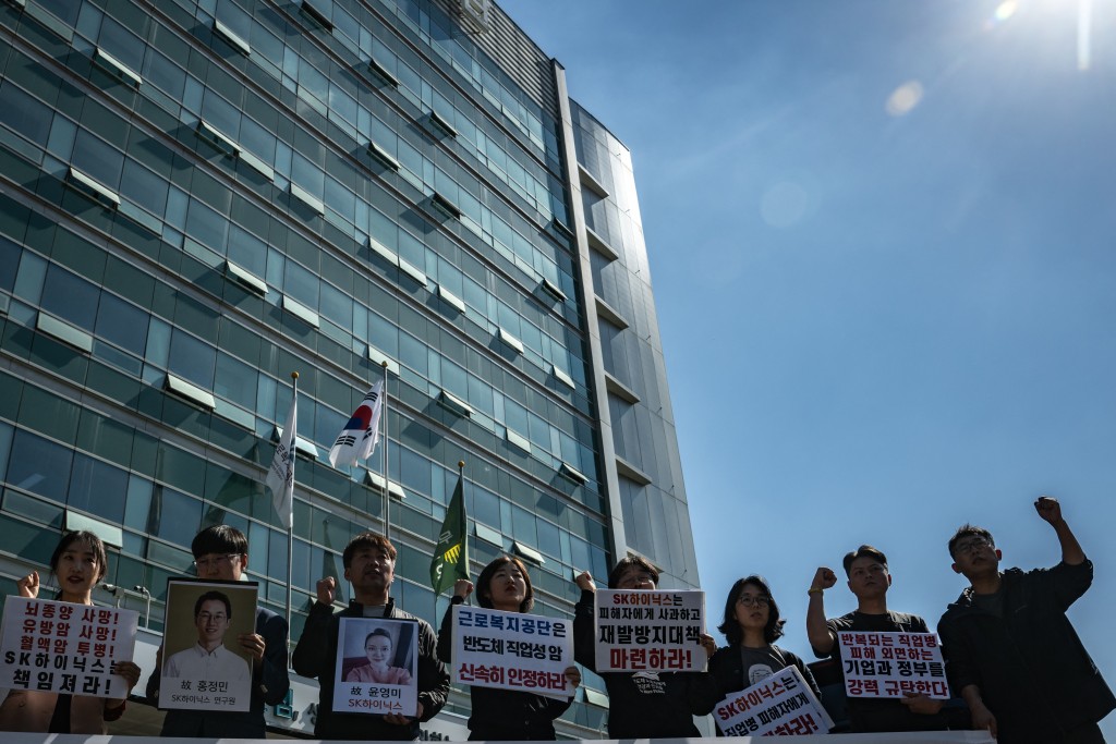 Photo by PHILIP FONG / AFP  Activists and relatives of employees of South Korean semiconductor company SK hynix chant slogans outside the Seoul Southern Branch of the Korea Workers' Compensation and Welfare Service in Seoul on October 7, 2026.