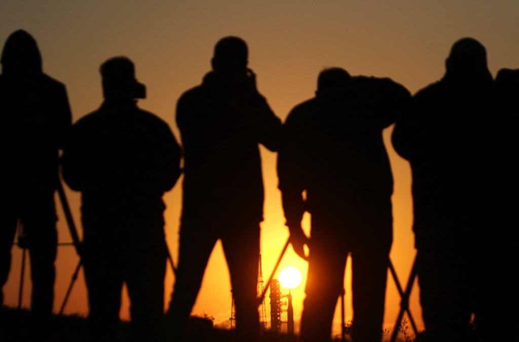 Photo by GREGG NEWTON / AFP  News media gather to view the NASA's Artemis II Space Launch System (SLS) rocket and Orion spacecraft at Launch Pad 39B at sunrise at the Kennedy Space Center in Cape Canaveral, Florida on March 24, 2026.