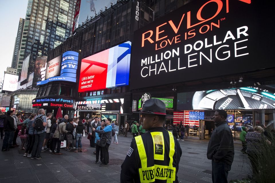 A Public Safety officer keeps watch as people stand in front of a billboard owned by Revlon that takes their pictures and displays them in Times Square in the Manhattan borough of New York. (Reuters) A Public Safety officer keeps watch as people stand in front of a billboard owned by Revlon that takes their pictures and displays them in Times Square in the Manhattan borough of New York. (Reuters)