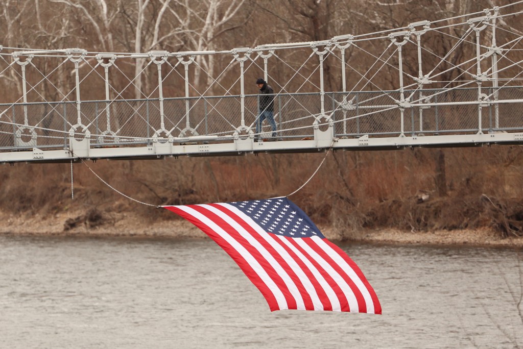Photo by CHARLY TRIBALLEAU / AFP  A man walks on a bridge crossing the Delaware river in the countryside town of Lumberville, Pennsylvania on January 14, 2026.