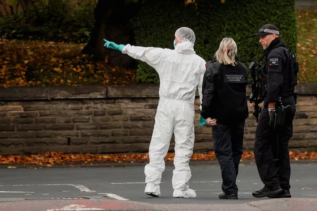 A forensic technician and police officers work at the scene after a man drove a car into pedestrians and stabbed a security guard in an attack at a synagogue where worshippers were marking Yom Kippur, the holiest day on the Jewish calendar, according to the British police, in north Manchester, Britain, October 2, 2025. REUTERS/Phil Noble