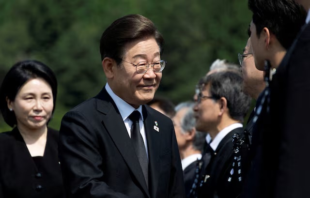 South Korean President Lee Jae-myung (C) and his wife Kim Hye-Kyung (L) arrive for a ceremony to mark the 70th Memorial Day at the Seoul National Cemetery in Seoul, South Korea, 06 June 2025. JEON HEON-KYUN/Pool via REUTERS/File Photo