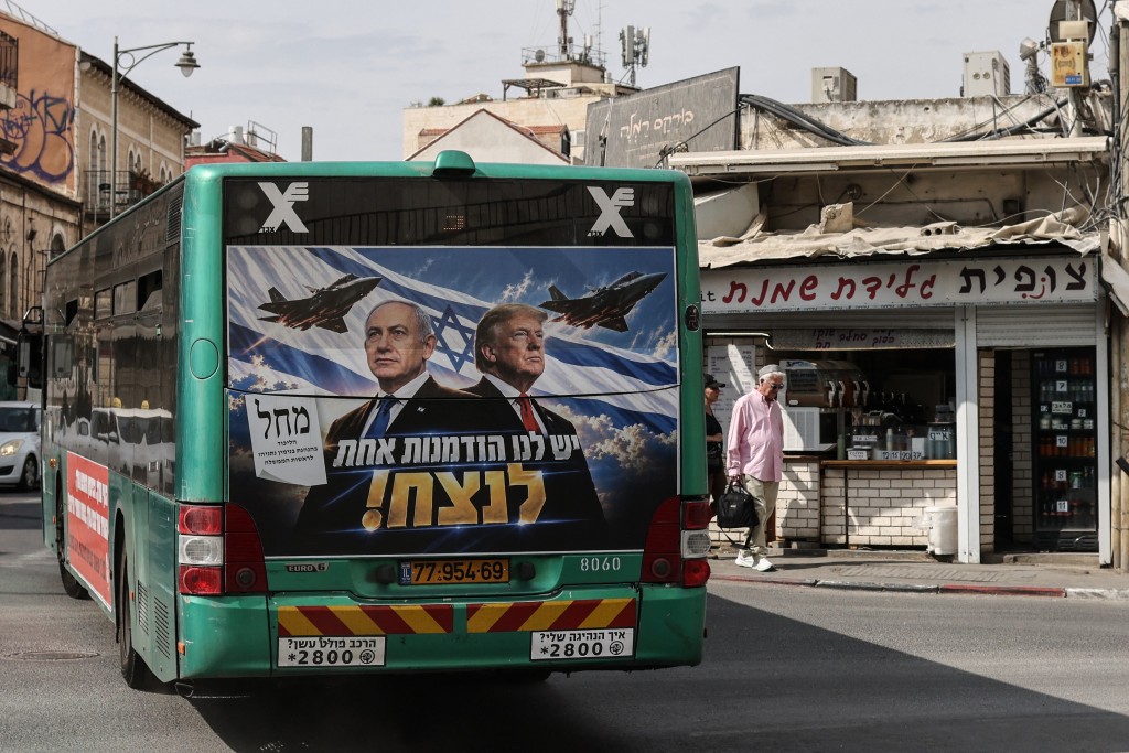  A bus bearing a campaign poster featuring Israeli Prime Minister and Likud party chairman Benjamin Netanyahu alongside US President Donald Trump drives through Jerusalem on October 26, 2026, on the eve of Israel's legislative elections. (Photo by AHMAD GHARABLI / AFP)