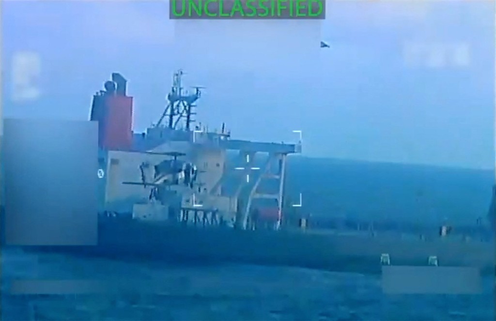A U.S. military helicopter flies near an oil tanker during a raid described by U.S. Attorney General Pam Bondi as its seizure by the United States off the coast of Venezuela, December 10, 2025, in a still image from video. U.S. Attorney General/Handout via REUTERS.