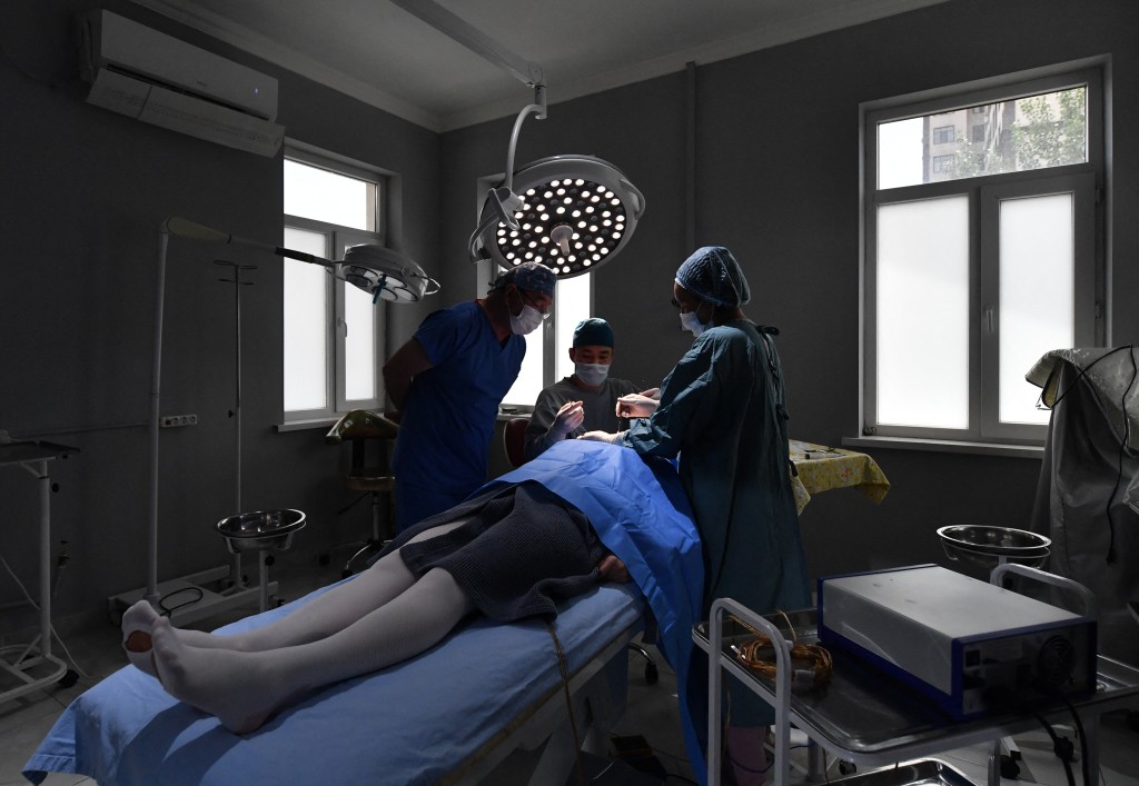Kyrgyz plastic surgeon Iskender Kachkinbayev oversees a plastic surgery in Bishkek on May 18, 2026. (Photo by Vyacheslav OSELEDKO / AFP)