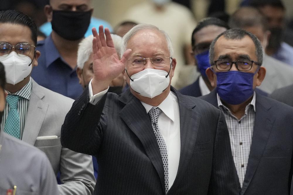 Former Malaysian Prime Minister Najib Razak, center, wearing a face mask, waves as he arrives at the Court of Appeal in Putrajaya, Malaysia. (AP) Former Malaysian Prime Minister Najib Razak, center, wearing a face mask, waves as he arrives at the Court of Appeal in Putrajaya, Malaysia. (AP)