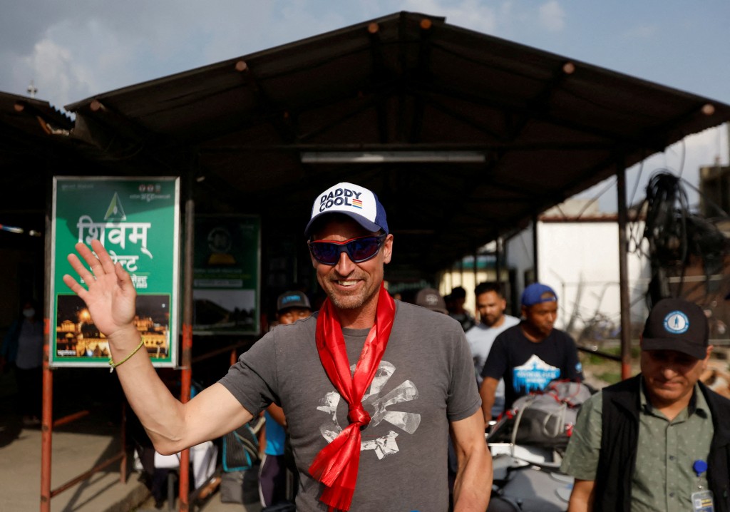 British climber Kenton Cool, 49, waves towards the media personnel, upon his arrival at the airport, as he returns after completing his 17th ascent of Mount Everest, which is the most by any foreign climber, in Kathmandu, Nepal May 19, 2023. (Reuters)