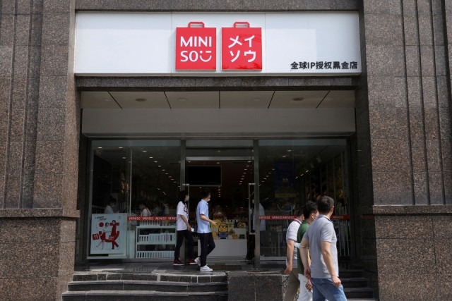 People walk past a store of Chinese retailer Miniso in Beijing, China. REUTERS