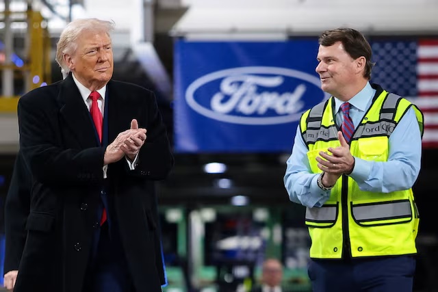 U.S. President Donald Trump and CEO of Ford Jim Farley clap, as President Trump visits a Ford production center, in Dearborn, Michigan, U.S., January 13, 2026. REUTERS/Evelyn Hockstein