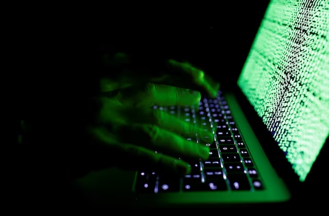 A man types on a computer keyboard in front of the displayed cyber code in this illustration picture taken on March 1, 2017. REUTERS/Kacper Pempel/Illustration 