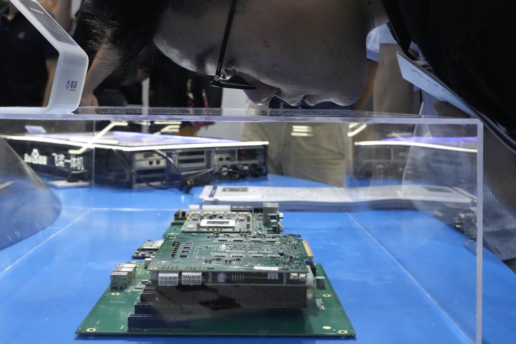 A visitor examines a computer chipset at the booth for Chinese semiconductor and chip developer Kunlunxin during the World AI Conference in Shanghai, Wednesday, July 5, 2023. China's government appealed to Japan on Monday, July 24, 2023 not to disrupt the semiconductor industry after curbs on exports of Japanese chip-making technology took effect, adding to technology restrictions Washington and its allies have imposed on China on security grounds. (AP Photo/Ng Han Guan)