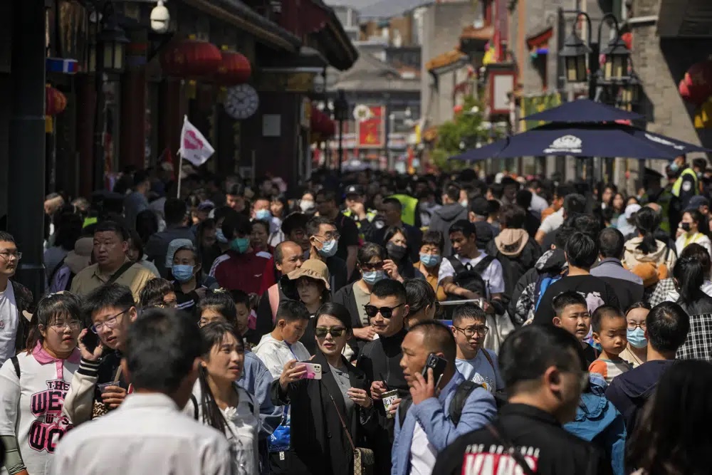 Crowds of visitors tour at Qianmen pedestrian shopping street during the May Day holiday in Beijing, Monday, May 1, 2023. A large number of workers and activists in Asian countries are set to mark May Day on Monday with protests calling for higher salaries and better working conditions, among other demands. (AP)