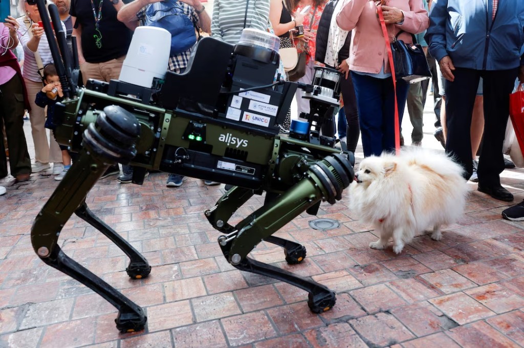 A dog named Lucy, 4, smells a police robot dog aimed at helping enforce traffic laws for E-scooters, during its presentation to the media, in Malaga, southern Spain, March 19. REUTERS/Jon Nazca