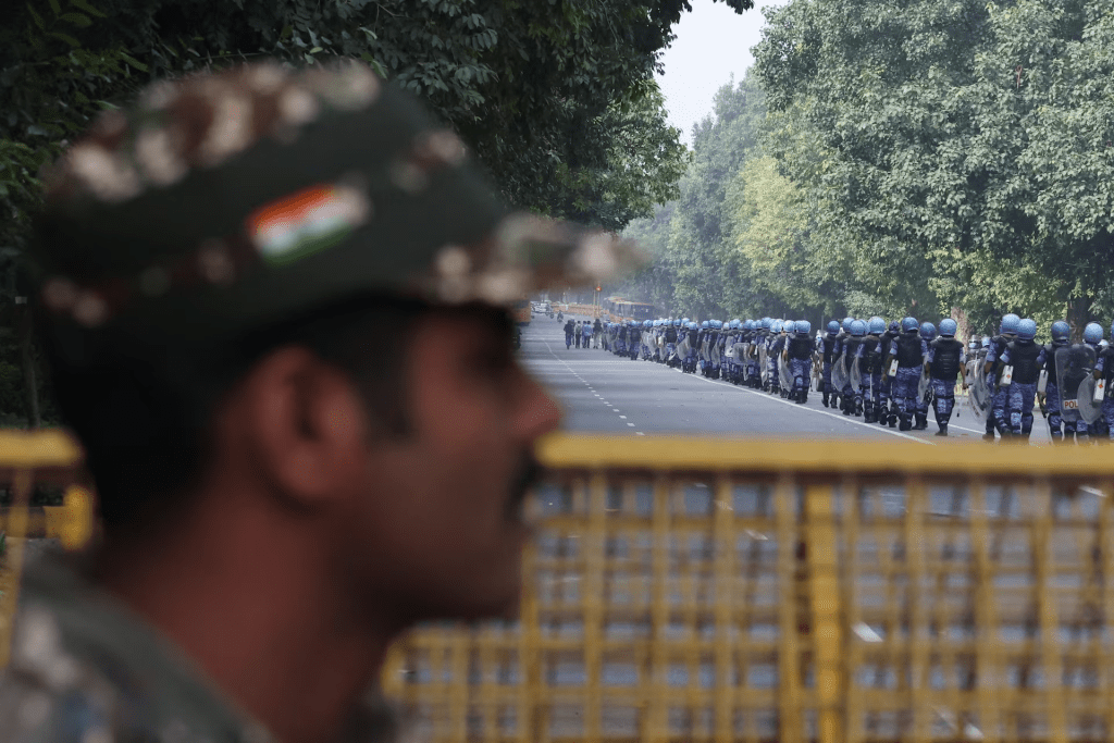A security official watches as Rapid Action Force (RAF) personnel march on the day of a protest by the Cockroach Janta Party (CJP) seeking the resignation of India's Chief Election Commissioner, Gyanesh Kumar, in New Delhi, India, October 10, 2026. REUTERS/Priyanshu Singh