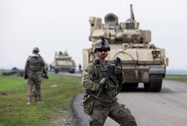 A soldier from the US-led coalition stands guard during a joint U.S.- Kurdish-led Syrian Democratic Forces (SDF) patrol in the countryside of Qamishli in northeastern Syria February 8, 2024. REUTERS/Orhan Qereman/File Photo 