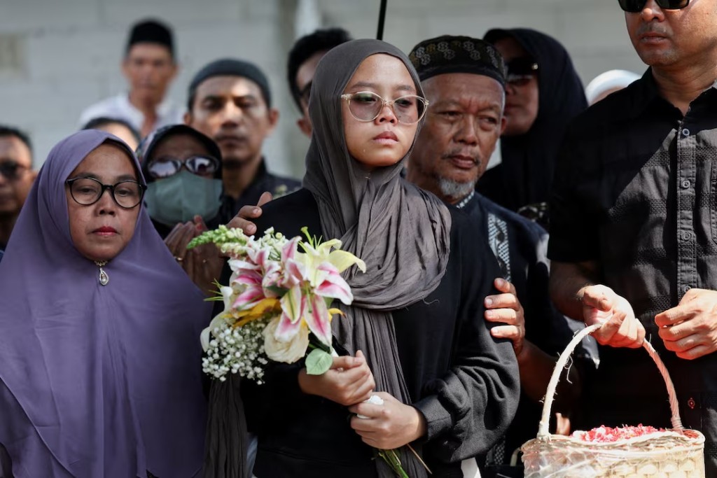  Putri, sister of Nur Aina Eka Rahmadhyna, a 32-year-old journalist with KompasTV, who was killed in the deadly collision between a commuter line train and a long-distance train on Monday, and other relatives attend the funeral in Bekasi, on the outskirts of Jakarta, Indonesia, April 29, 2026. REUTERS/Willy Kurniawan