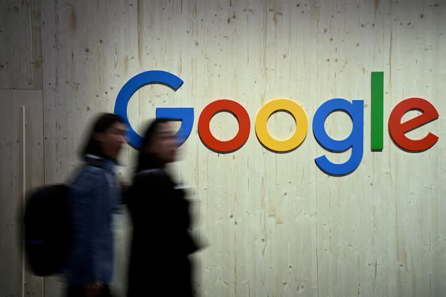 People walk next to a Google logo during a trade fair in Hannover Messe, in Hanover, Germany, April 22, 2024. REUTERS/Annegret Hilse/File Photo